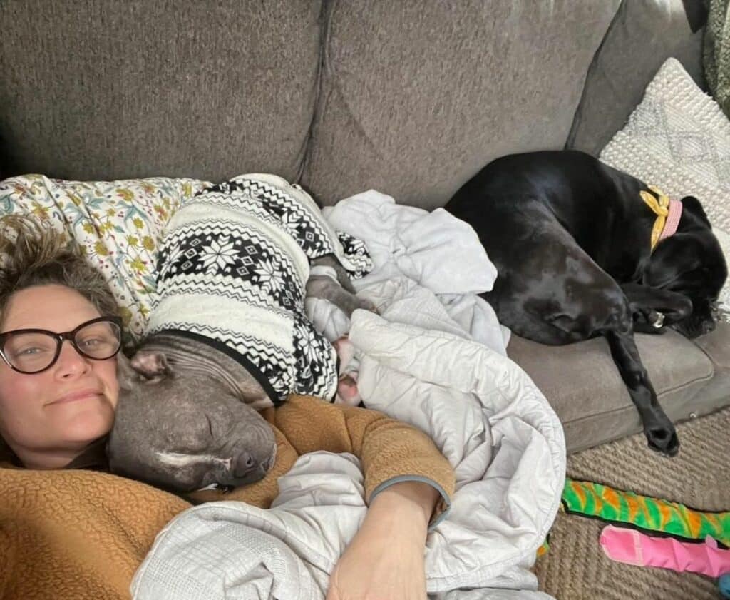 woman laying with two dogs e1715074537980